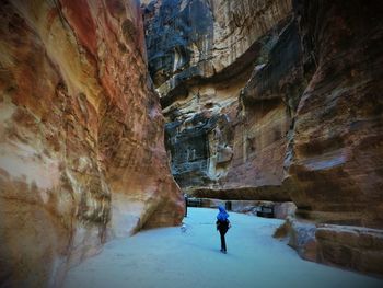 Rear view of woman standing by cliffs