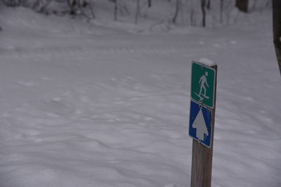 Road sign on snow covered land