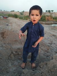 Portrait of cute boy standing on land