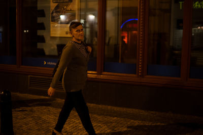 Side view of young man looking away in city at night