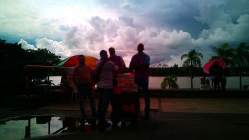 Men with arms raised against sky