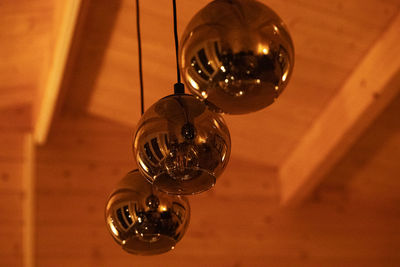 Low angle view of light bulb hanging on ceiling