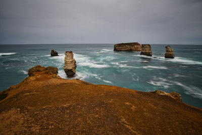Rocks on sea shore against sky
