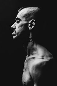 Close-up of young man against black background