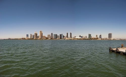City at waterfront against clear sky