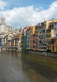 View of buildings in city against cloudy sky