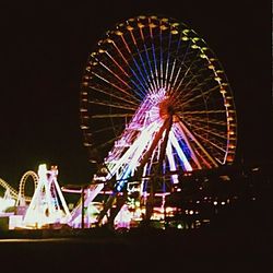 Low angle view of ferris wheel against sky at night