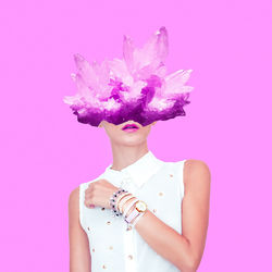 Digital composite image of woman with crystals standing against pink backgrounds