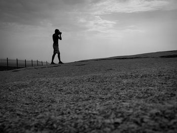 Silhouette woman standing on field against sky