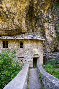 Footpath amidst rocks and trees outside house