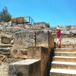 Woman on staircase against clear sky