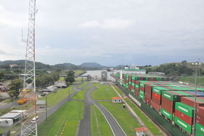 Cars on road against cloudy sky