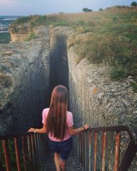 Rear view of woman standing on railing