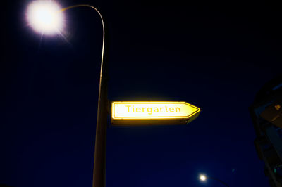 Low angle view of road sign against sky at night