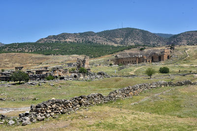 View of old building by mountain against clear sky