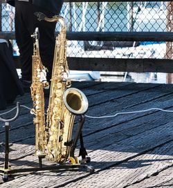 Two saxophones on a stand, on the edge of the street musicians' stage.