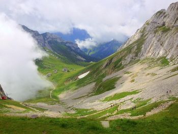 Scenic view of grassy landscape against cloudy sky