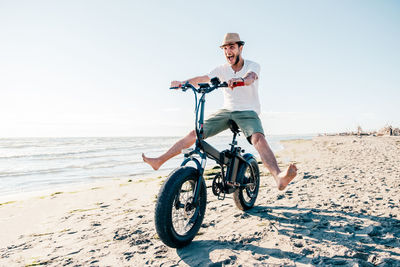 Man riding bicycle on beach