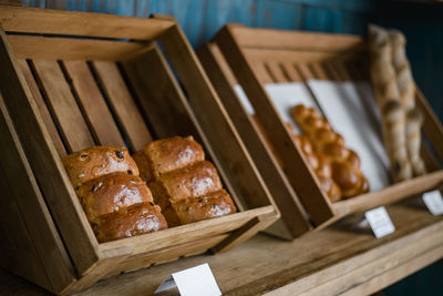 Freshly baked bread in a wooden tray on a shelf in the bakery.