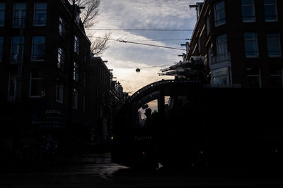 Street amidst buildings against sky at dusk