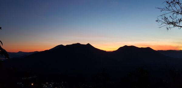 Scenic view of silhouette mountains against sky at sunset