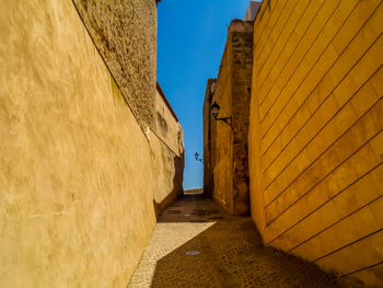 Narrow alley amidst buildings against sky