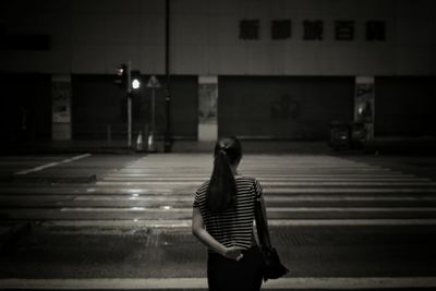 Rear view of woman standing on street at night