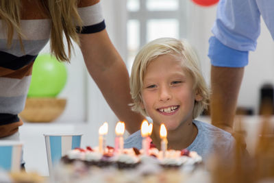 Parents with boy looking at birthday cake