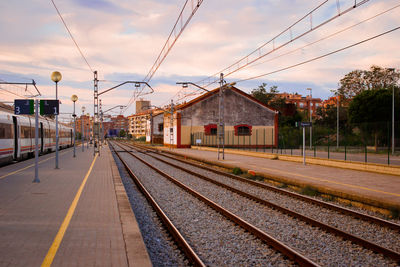 Railroad station platform against sky at morning