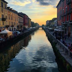 Canal amidst buildings in city against sky