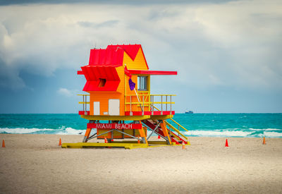 Lifeguard hut on beach against sky