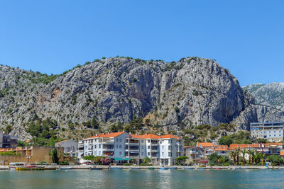 Scenic view of lake and mountains against clear blue sky