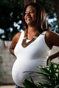 Side view of pregnant woman standing outdoors