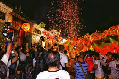 People on street with chinese dragon in city at night during traditional festival