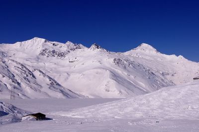 Scenic view of snowcapped mountains against clear blue sky