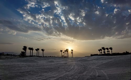 Panoramic view of snowy field against sky during sunset