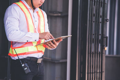 Midsection of man using mobile phone