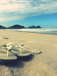 Scenic view of beach against cloudy sky