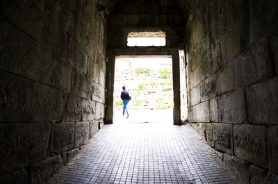 Rear view of man walking on footpath