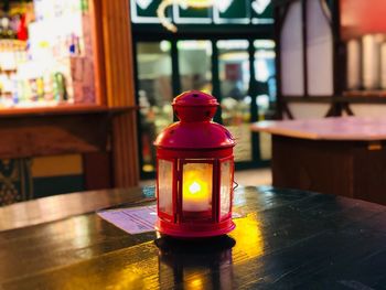 Illuminated lantern on table in restaurant