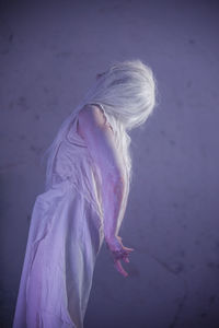 Woman performing against wall in abandoned building