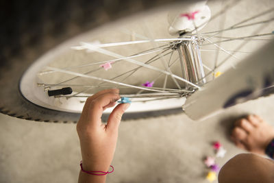 Cropped image of girl decorating bicycle tire