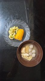 High angle view of fresh yellow flowers in bowl on table