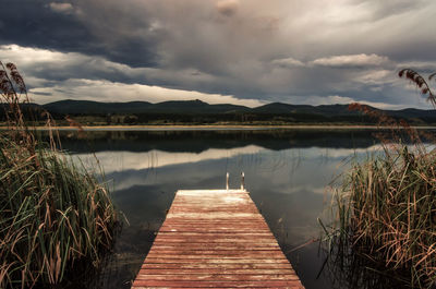 Pier over lake against sky