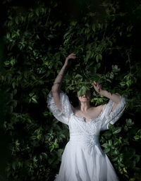 Rear view of woman standing against plants