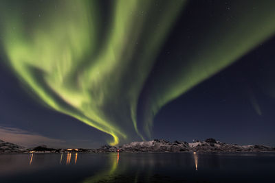 Scenic view of aurora borealis over lake at night