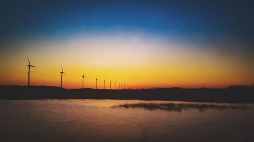 Silhouette of wind turbines at sunset