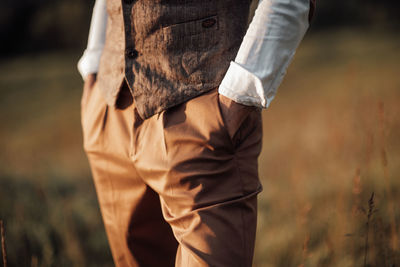 Midsection of man standing on field