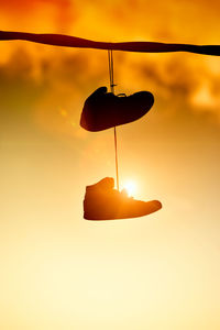 Low angle view of illuminated lamp against sky during sunset