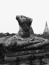 Close-up of statue against temple against clear sky